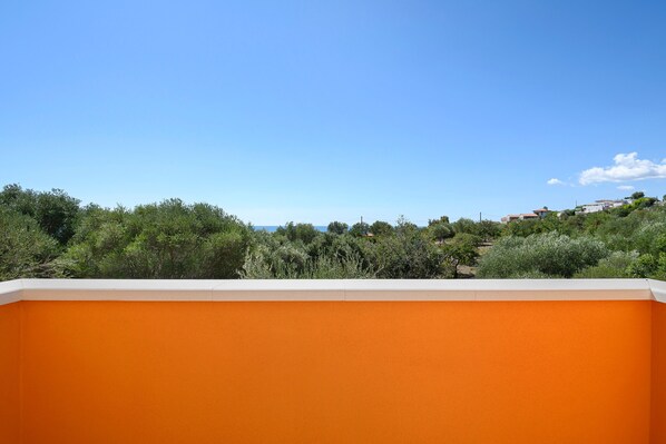 A view of a building with an orange facade and a clear blue sky.