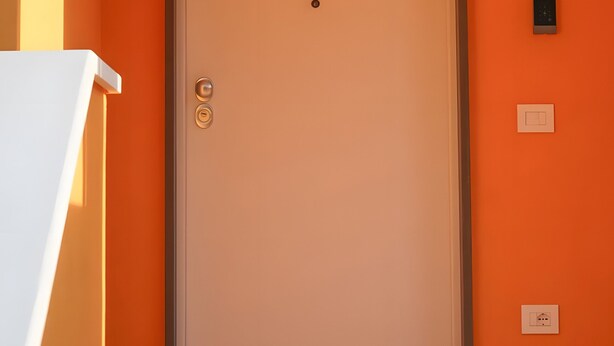 A closed door with a nameplate, a wall-mounted light, and a power outlet. - Oliblu Holiday Home – Superior Taggiasca Apartment with Partial Sea View (Vibonati)