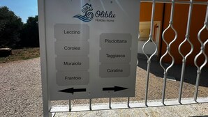 A sign with room names and directional arrows, indicating the layout of a holiday home. - Oliblu Holiday Home – Superior Taggiasca Apartment with Partial Sea View (Vibonati)