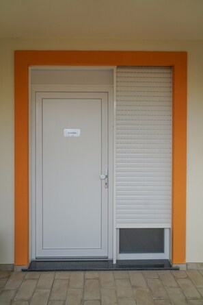 Una puerta con un letrero que dice 'Corolea' y una puerta corredera con persianas horizontales.