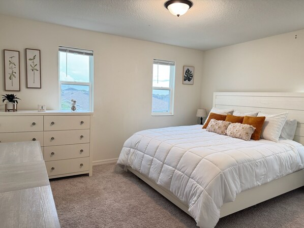 A bedroom with a bed, dresser, and two windows. - Winter Haven 5BR Family Retreat- Near LEGOLAND + Disney, Family-Friendly (Winter Haven)