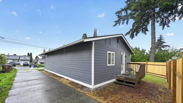 A small, single-story building with a grey exterior and a white door. - 2 Bed Cottage, Close to Tacoma Mall, Freeways (Tacoma)