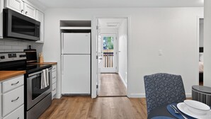 A modern kitchen with white cabinetry, a stainless steel oven, and a microwave. - 2 Bed Cottage, Close to Tacoma Mall, Freeways (Tacoma)