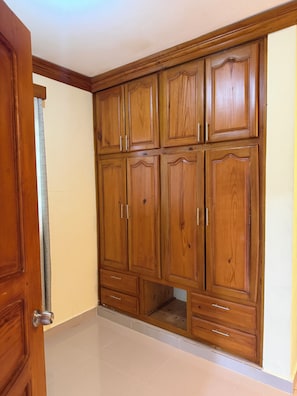 A wooden wardrobe with multiple doors and drawers. - El Bonao Aparthotel (Higüey)