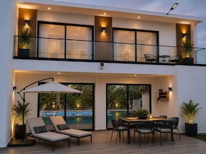A modern two-story house with a balcony, a dining area, and a pool. - Family Luxury Villa  Primaveral 4 / Near Beaches (La Altagracia)