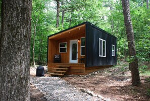 Eine kleine Holzhütte mit Veranda und Treppe.