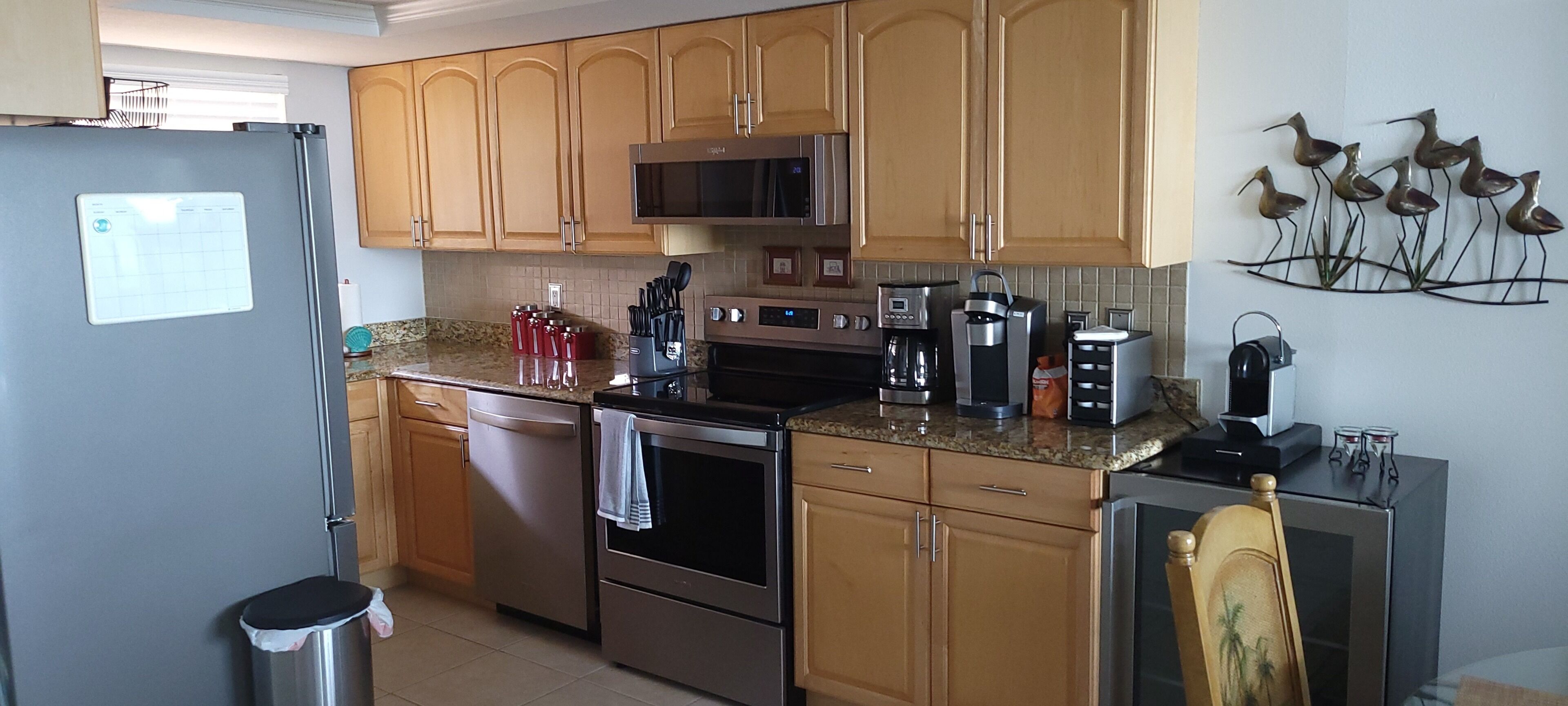 A kitchen with wooden cabinets, stainless steel appliances, a microwave, and a coffee maker.