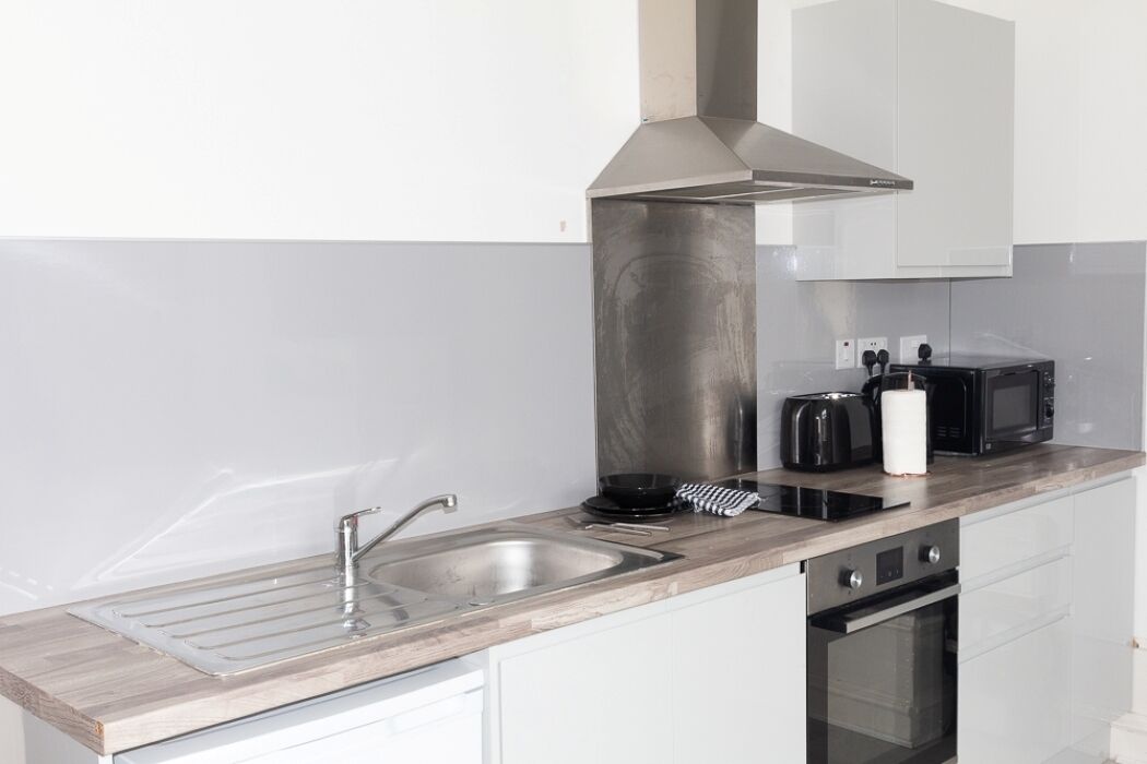 A modern kitchen with a stainless steel sink, a microwave, and a toaster.