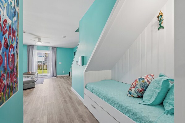 Een slaapkamer met een bed, een raam en een deur naar een balkon.