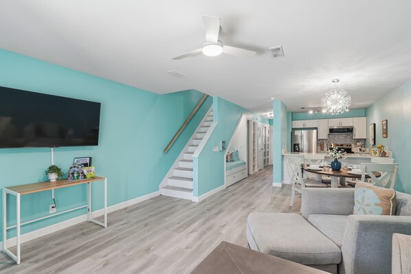 Una sala moderna con escaleras, un comedor y una cocina.