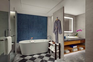 Un baño moderno con una bañera independiente, un tocador con espejo y una zona de ducha.
