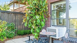 A patio with a table and chairs, a brick wall, and a wooden fence. - Stunning 2-bed Apt in the Heart of Queen Anne (Seattle)