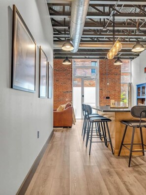 Ein modernes Interieur mit Bar, Sitzgelegenheiten und freiliegenden Backsteinwänden.