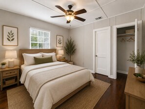 Ein Schlafzimmer mit einem Bett, Nachttischen, einem Deckenventilator, einem Fenster und einem Kleiderschrank.