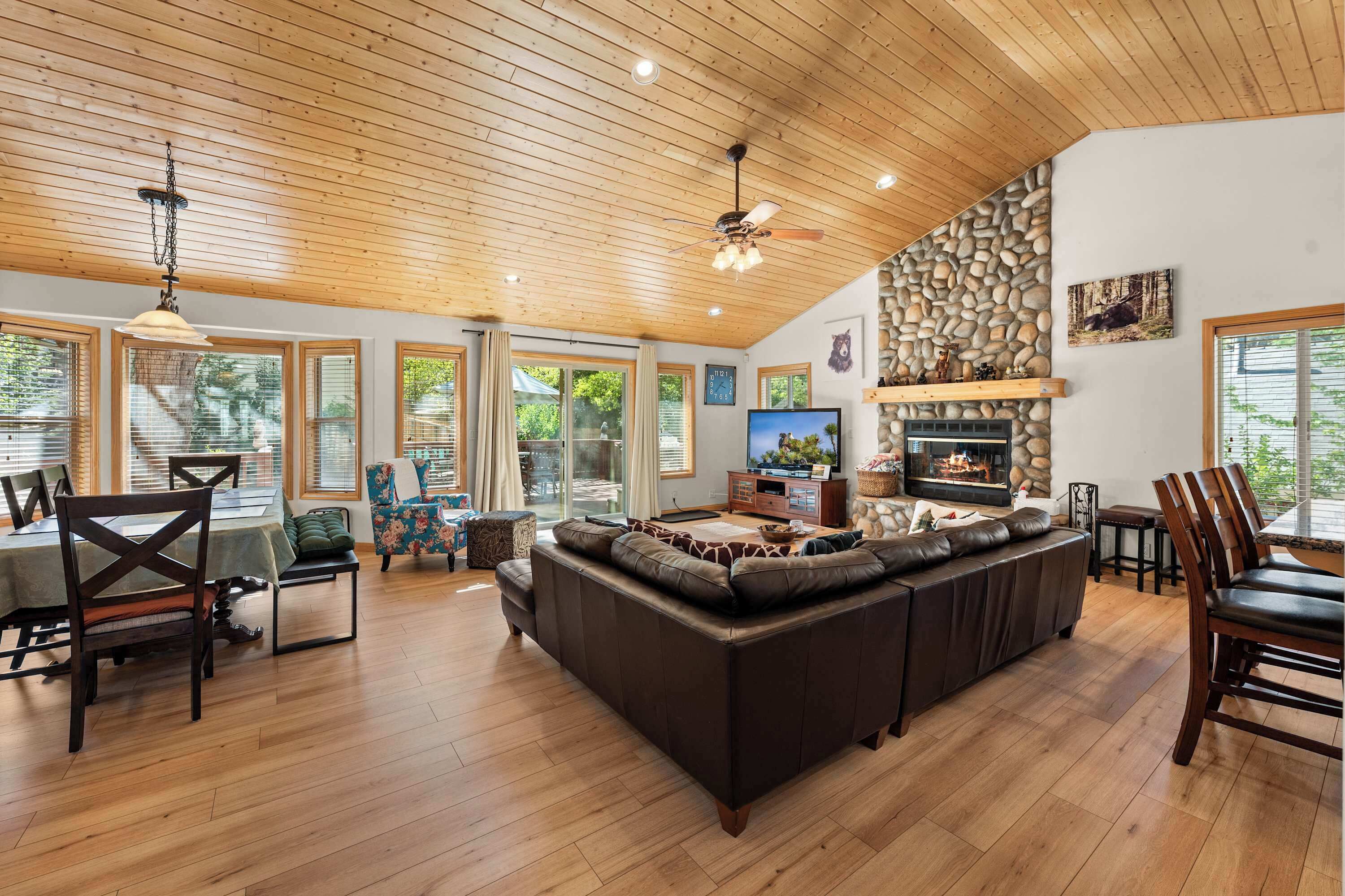 A spacious living room with a large sectional sofa, a fireplace, and a stone accent wall.