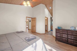 A bedroom with a large bed, wooden wardrobe, and a ceiling fan. - Big Bear House | Hot Tub | Summit Shuttle | Max 11 (Big Bear Lake)