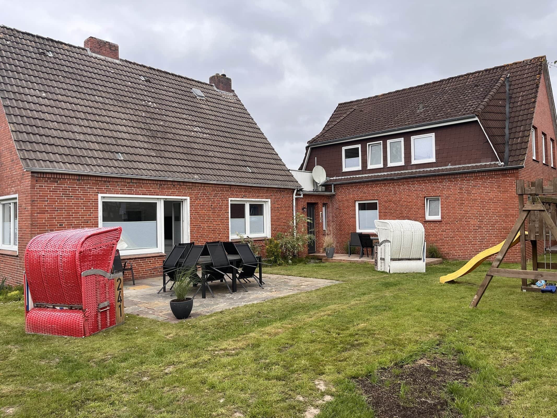 A residential property with a brick exterior, a covered patio with outdoor furniture, and a play area with a slide.