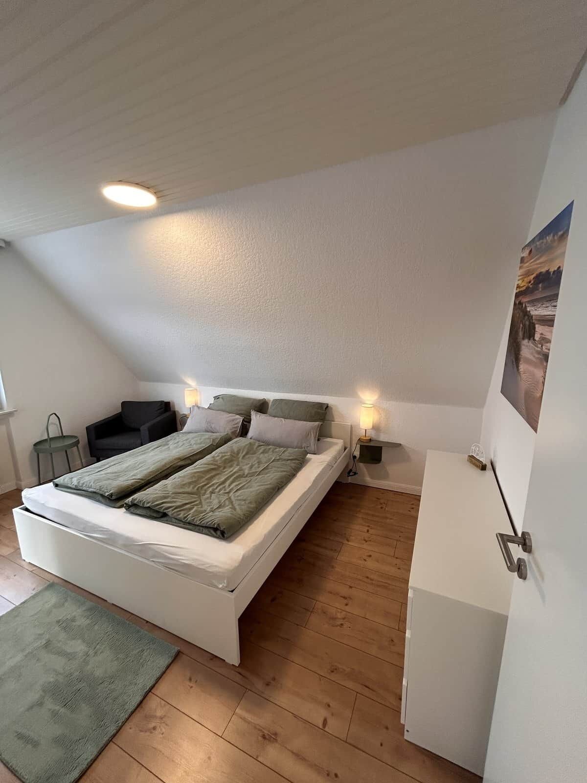 Une chambre à coucher comprenant un lit, des tables de chevet, une commode, un bureau et une chaise.