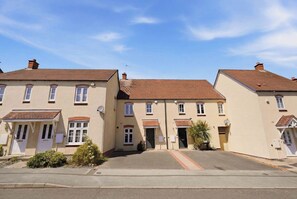 A row of two-story buildings with a central entrance, likely a residential complex or small hotel. - Modern 3BR Retreat|Garden & Parking (Solihull)