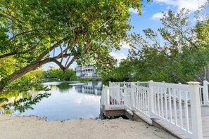 A waterfront property with a wooden dock, a white fence, and a house in the background. - New Key Largo Kawama . 2 Kings . Matina . Pickleball (Key Largo)