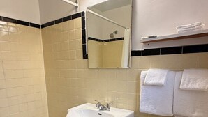 Ein Badezimmer mit Badewanne, Waschbecken, Toilette und Duschbereich.