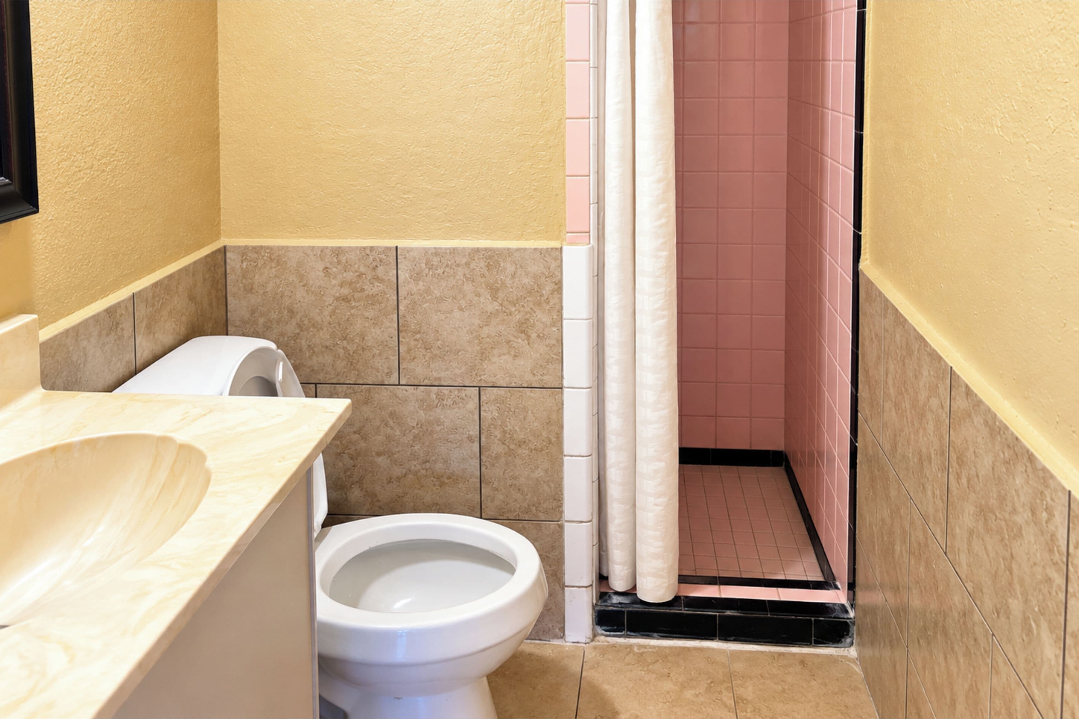 A bathroom with a toilet, a sink, and a shower curtain.