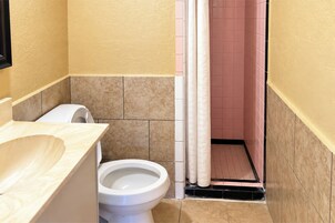 Un baño con inodoro, lavabo y cortina de ducha.