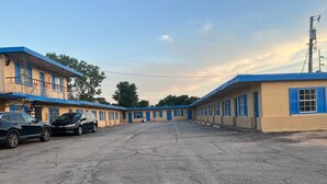 Une rangée de bâtiments d’un motel, avec un parking devant.