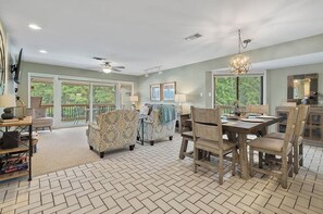 A spacious living room with a dining area, large windows, and a ceiling fan. - 2-bedroom condo in perfect Hot Springs with cool AC (Hot Springs)