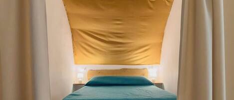 Ein Schlafzimmer mit einem Bett, einem Holz-Kopfteil und Vorhängen.