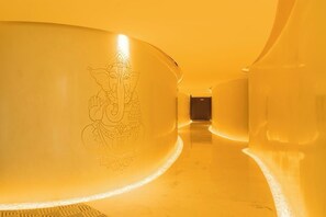 A corridor with a continuous curved wall featuring an embossed design.