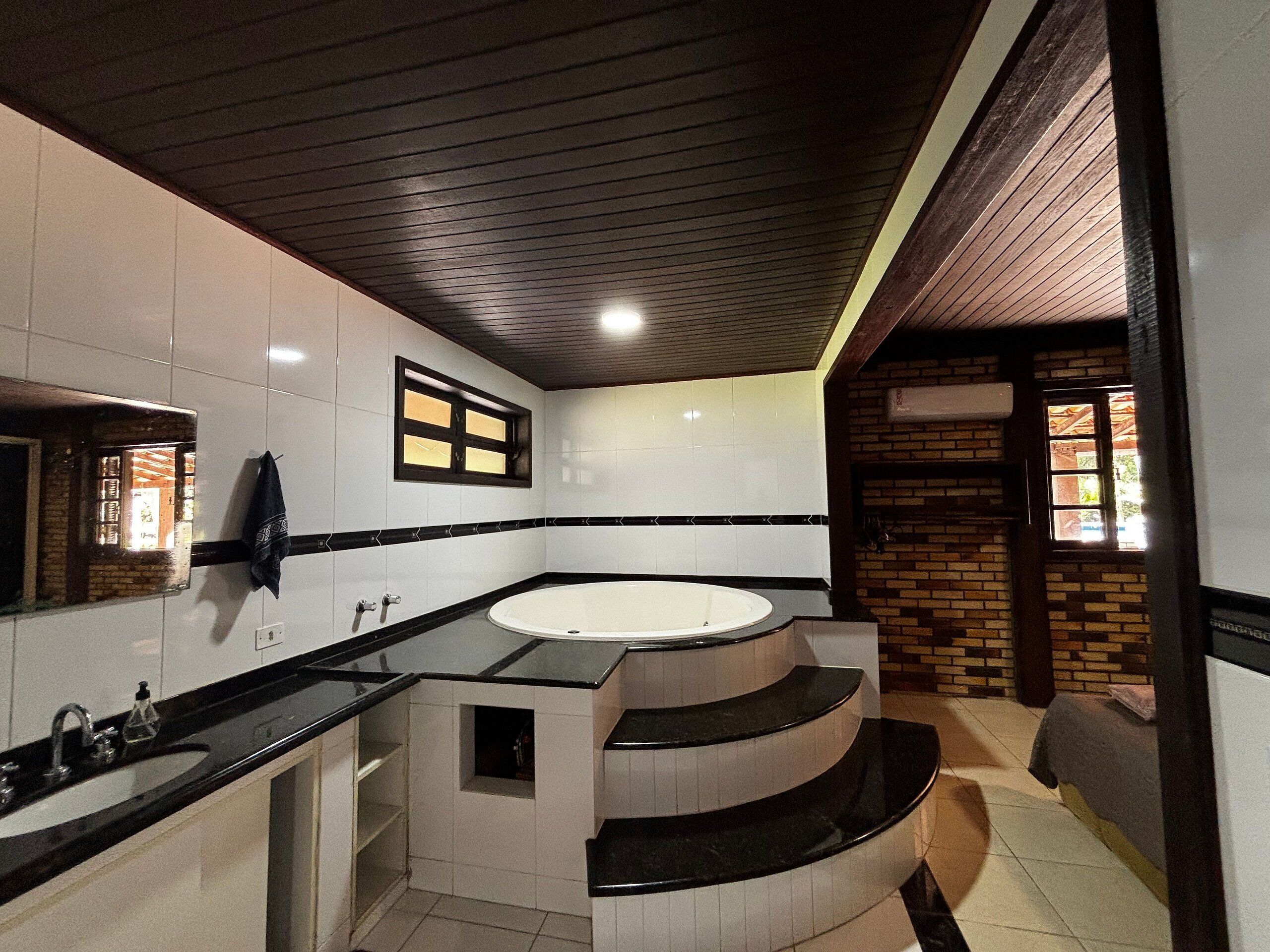A modern bathroom with a large bathtub, a vanity with a sink, and a mirror.