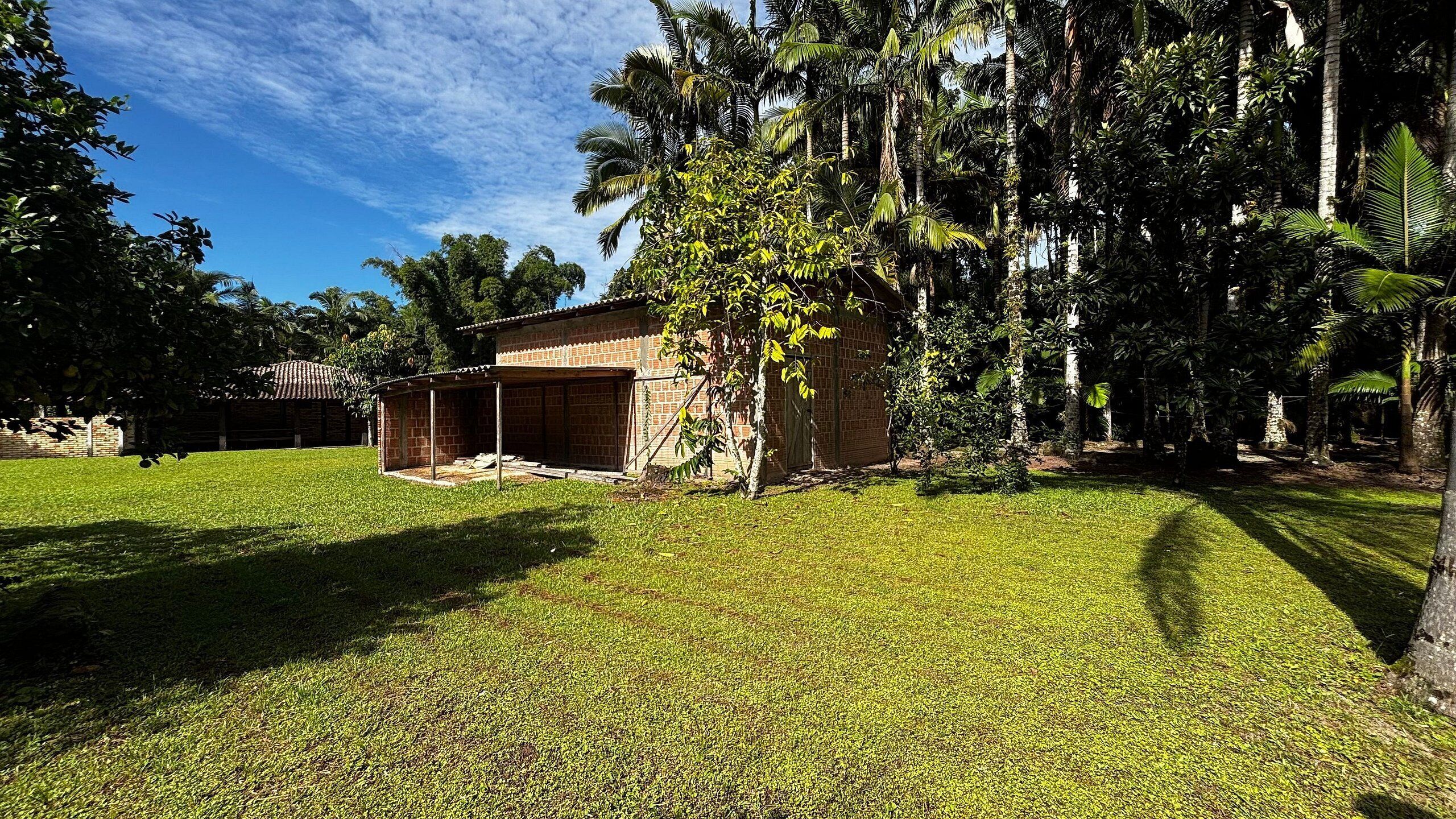 Um bairro residencial com uma casa de tijolos, varanda coberta e gramado bem cuidado.