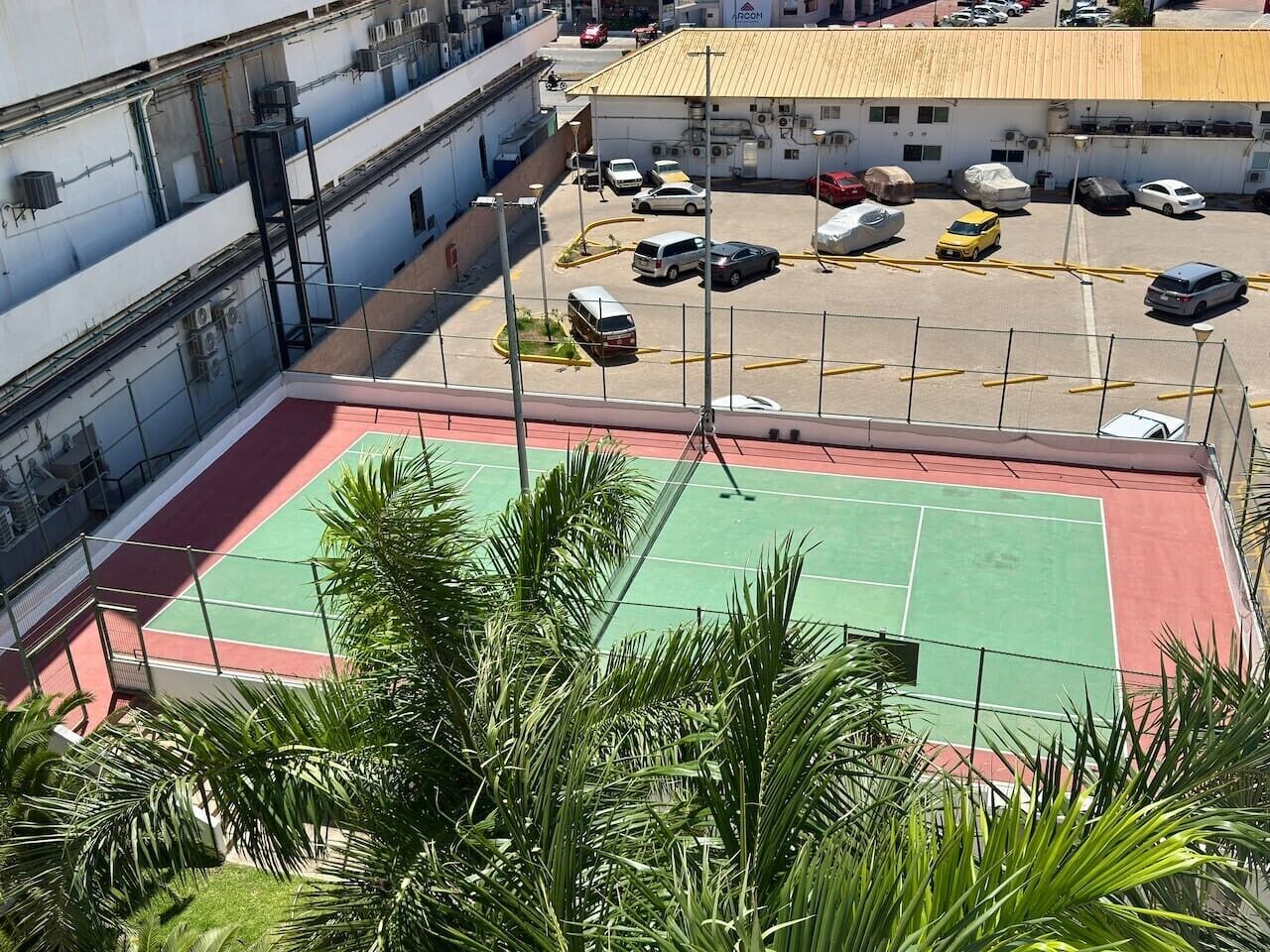 A multi-level parking area with a basketball court in the foreground.