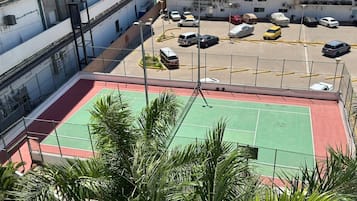 A multi-level parking area with a basketball court in the foreground.