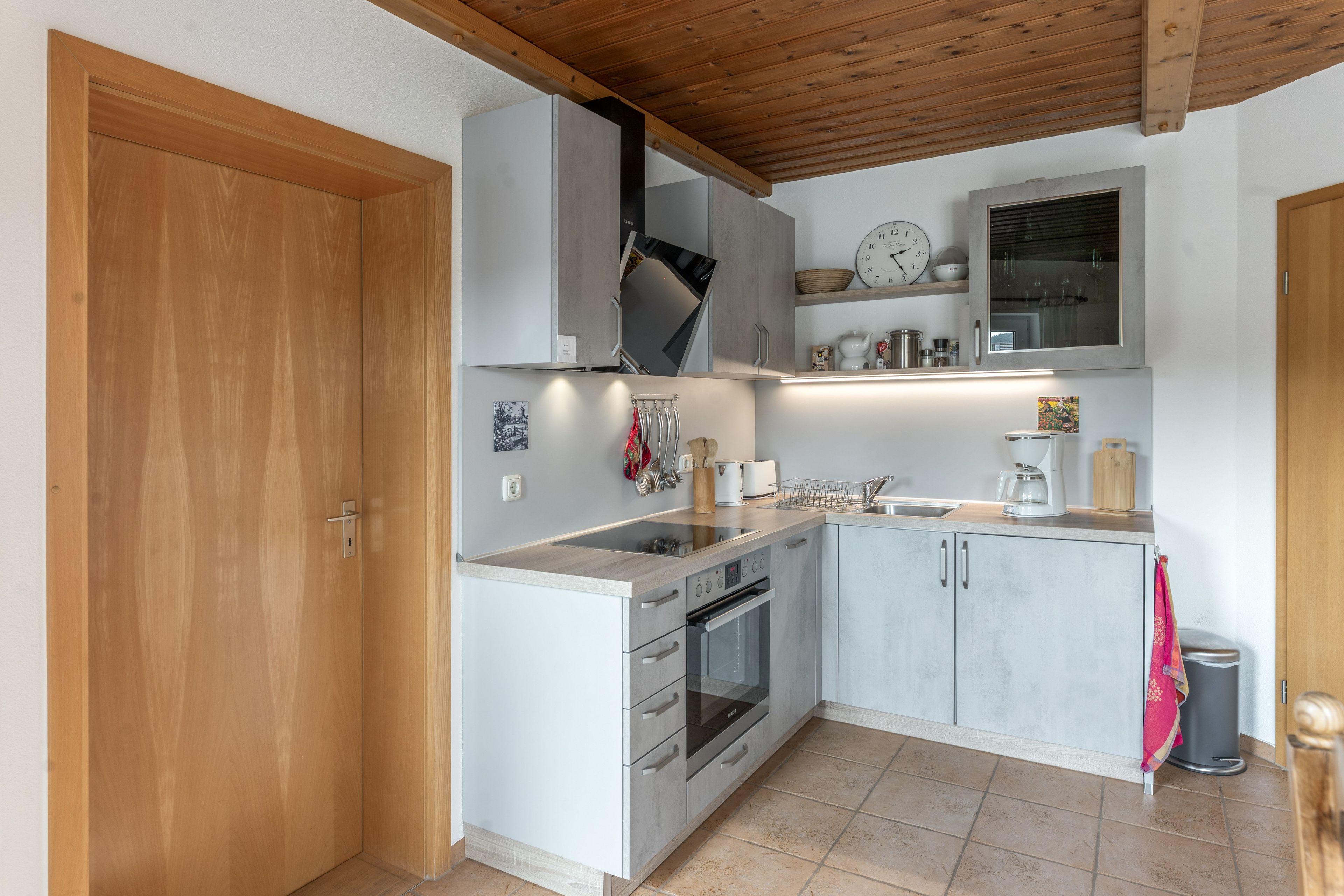 Eine kleine Küche mit eingebautem Backofen, einer Mikrowelle und einem Spülbecken.