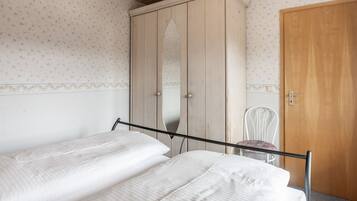 Ein Schlafzimmer mit Bett, Kleiderschrank und Stuhl.