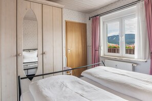 A bedroom with two beds, a wardrobe, a window with a view of the outdoors, and a radiator. - Apartment "Ferienwohnungen Oberwiesenthal" with Mountain View, Balcony, and Wi-Fi (Oberwiesenthal)