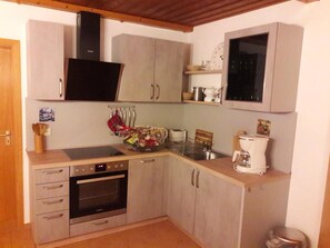 Cafetera o tetera, frigorífico, horno y placa de cocina