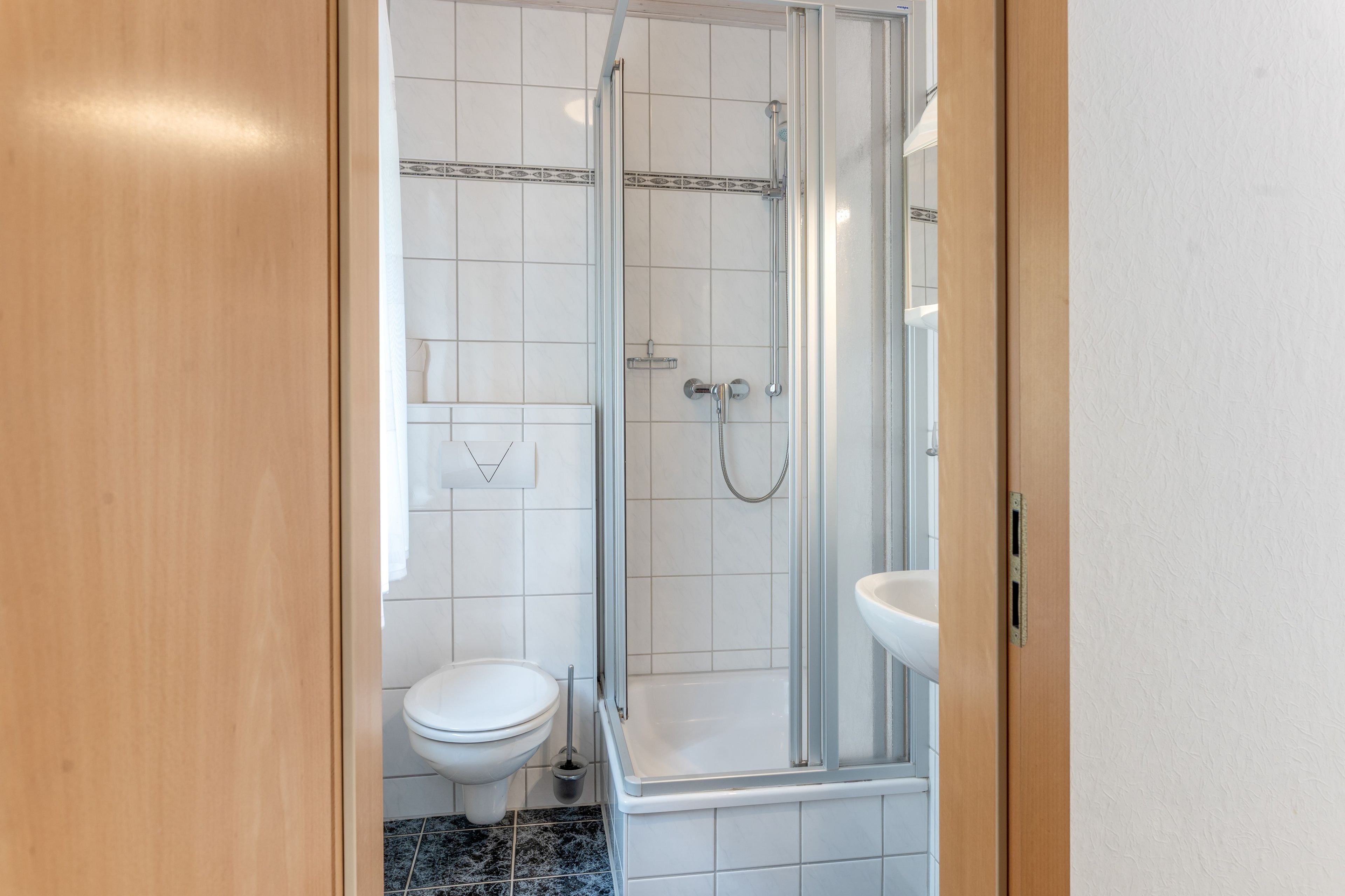 Ein Badezimmer mit Dusche, Toilette und Waschbecken.