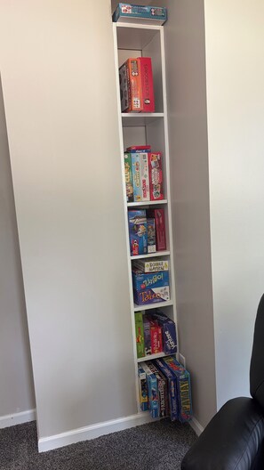A white shelving unit with various board games. - My Happy Place! "RoundWeGoToo" (Machesney Park)
