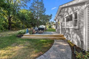 A residential property with a paved patio, outdoor furniture, and a garden area. - My Happy Place! "RoundWeGoToo" (Machesney Park)