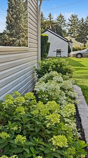 Ein Wohnhaus mit gepflegtem Garten, Rasenfläche und Garage.