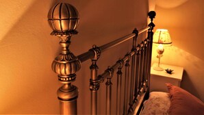 Una escalera con barandales de metal ornamentados y un remate decorativo.
