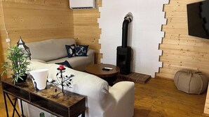 A cozy living room with a sofa, a coffee table, a fireplace, and a plant. - Casa del Mar Iznájar by Ruralidays (Córdoba)