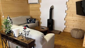 A cozy living room with a sofa, a coffee table, a fireplace, and a plant. - Casa del Mar Iznájar by Ruralidays (Córdoba)