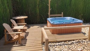 A wooden deck with a hot tub, Adirondack chairs, and a small round table. - Casa del Mar Iznájar by Ruralidays (Córdoba)