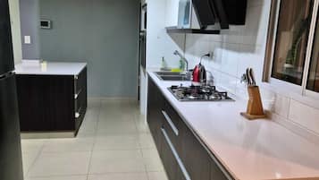 Une cuisine moderne équipée d’une cuisinière à gaz, d’un four à micro-ondes et d’un four encastré.