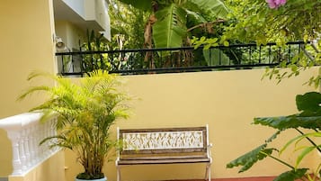 Un patio con un banco, plantas en macetas y un área con piedrecitas.