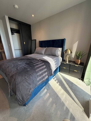 Ein modernes Schlafzimmer mit Bett, Nachttischen und einem Kleiderschrank.
